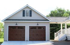 a two car garage in front of a white house