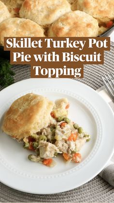 a white plate topped with chicken pot pie next to a skillet filled with biscuits