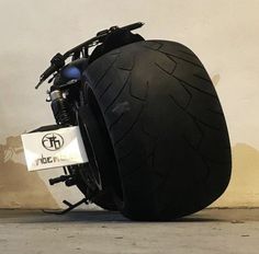 a motorcycle tire on the ground next to a wall