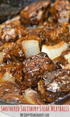 some meat and onions are cooking in a skillet with sauce on the side,