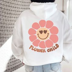 a person wearing a white hoodie with a flower child design on the front and back