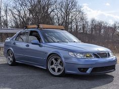 a blue car parked in front of some trees