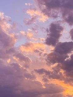 the airplane is flying high in the sky with clouds above it and another plane on the ground below