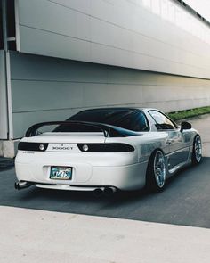 a white sports car parked in front of a building