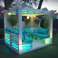 an outdoor living area is lit up with blue and green lights, including pillows on the couch