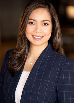 a woman in a suit smiling for the camera