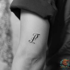 a woman's upper arm with the letter p tattooed on her left side forearm