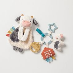 a toy cow and other toys on a white surface