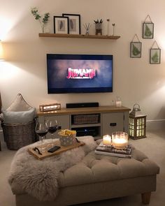 a living room filled with furniture and a flat screen tv mounted to the side of a wall