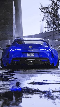 a blue sports car parked in the rain