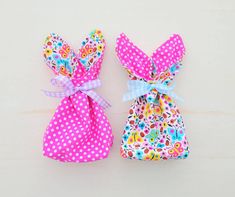 two small pink and blue bags with polka dots on them, one has a bow at the top