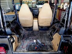 the inside of a vehicle with its door open and wires in it's trunk