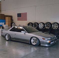 a car parked in a garage next to some tires