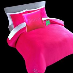 a pink comforter set with white trim and green shamrock on the pillow, in front of a black background