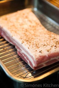 a piece of raw meat sitting on top of a metal rack in a kitchen oven