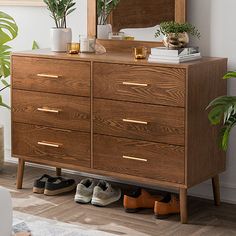 a wooden dresser with shoes and plants on top