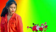 a woman standing in front of a rainbow colored background with flowers on her left side