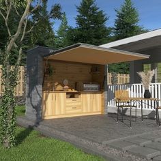 an outdoor kitchen is shown in the middle of a yard with tables and chairs around it