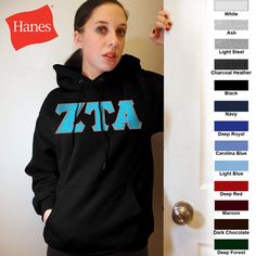 a woman wearing a blue hoodie with the letters xrp on it, standing in front of a door