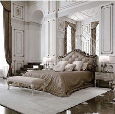 a large bed sitting in the middle of a bedroom next to a chandelier