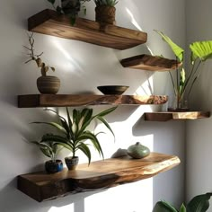 three wooden shelves with plants on them in the corner, and one shelf is made out of wood