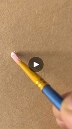 a person is holding a yellow and blue pen