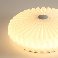 a light that is sitting on top of a white tablecloth with an oval hole in the center