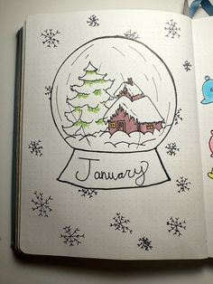 an open notebook with a drawing of a snow globe