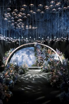 a stage with flowers and chandeliers hanging from the ceiling