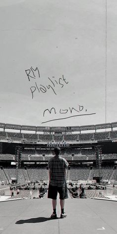 a man standing on top of a cement field next to an empty stadium filled with people