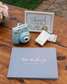 a table with a camera, notepad and other items sitting on top of it