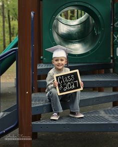 a young boy sitting on top of a wooden bench holding a sign that says $ 1, 000