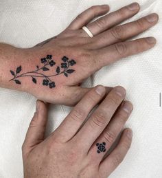 two hands with matching tattoos on them