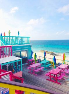 colorful tables and umbrellas are on the beach