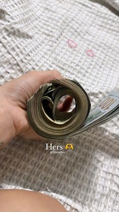 someone is holding money in their hand and it looks like they have rolled up some sort of paper