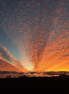 the sky is filled with colorful clouds as the sun sets in the distance behind it