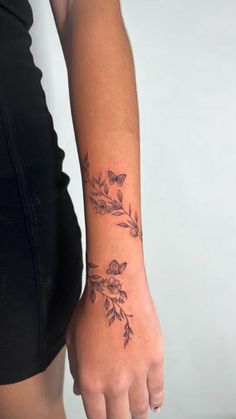 a woman's arm with flowers and leaves tattoo on the left side of her body