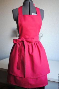 a red apron on a mannequin in front of a wall