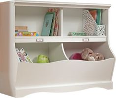 a white book shelf with books and stuffed animals