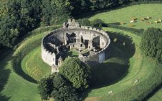 an aerial view of a castle surrounded by lush green fields and trees in the countryside