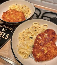 two plates of food on a stove top with one chicken and the other macaroni and cheese