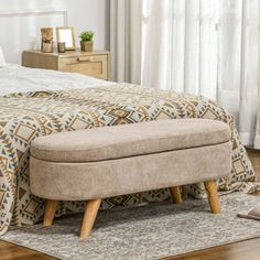 a bed sitting on top of a wooden floor next to a window