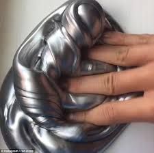 a woman's hand holding onto a shiny silver purse with her fingers on it