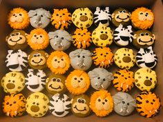 a box filled with cupcakes covered in frosting and decorated like animal faces