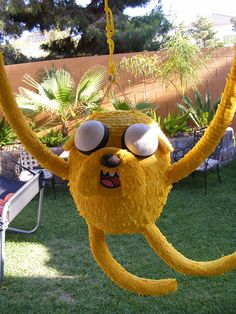 a large yellow monster hanging from a tree