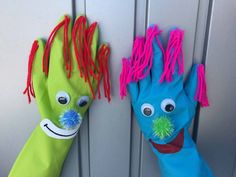 two colorful hand puppets are hanging on the side of a door, one with eyes and hair