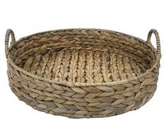 a round woven basket with handles on the bottom is shown in front of a white background