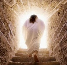 a man walking up some stairs with his hands in the air and light coming from behind him