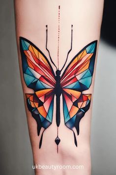 a colorful butterfly tattoo on the side of a woman's leg with geometric shapes