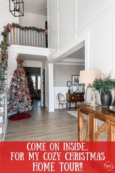 a christmas tree in the middle of a living room with stairs leading up to it